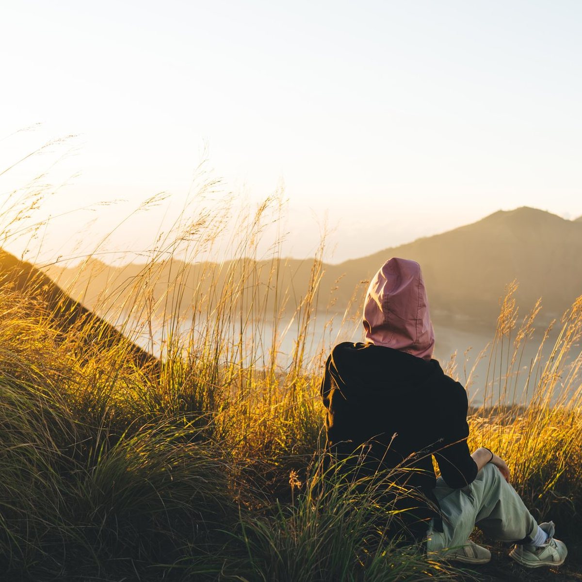 Femme voilée de dos face au lever du soleil, psychologue confiance en soi