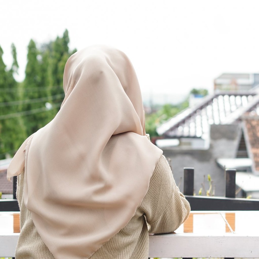 Femme voilée de dos sur un balcon, psychologue gestion de la colère